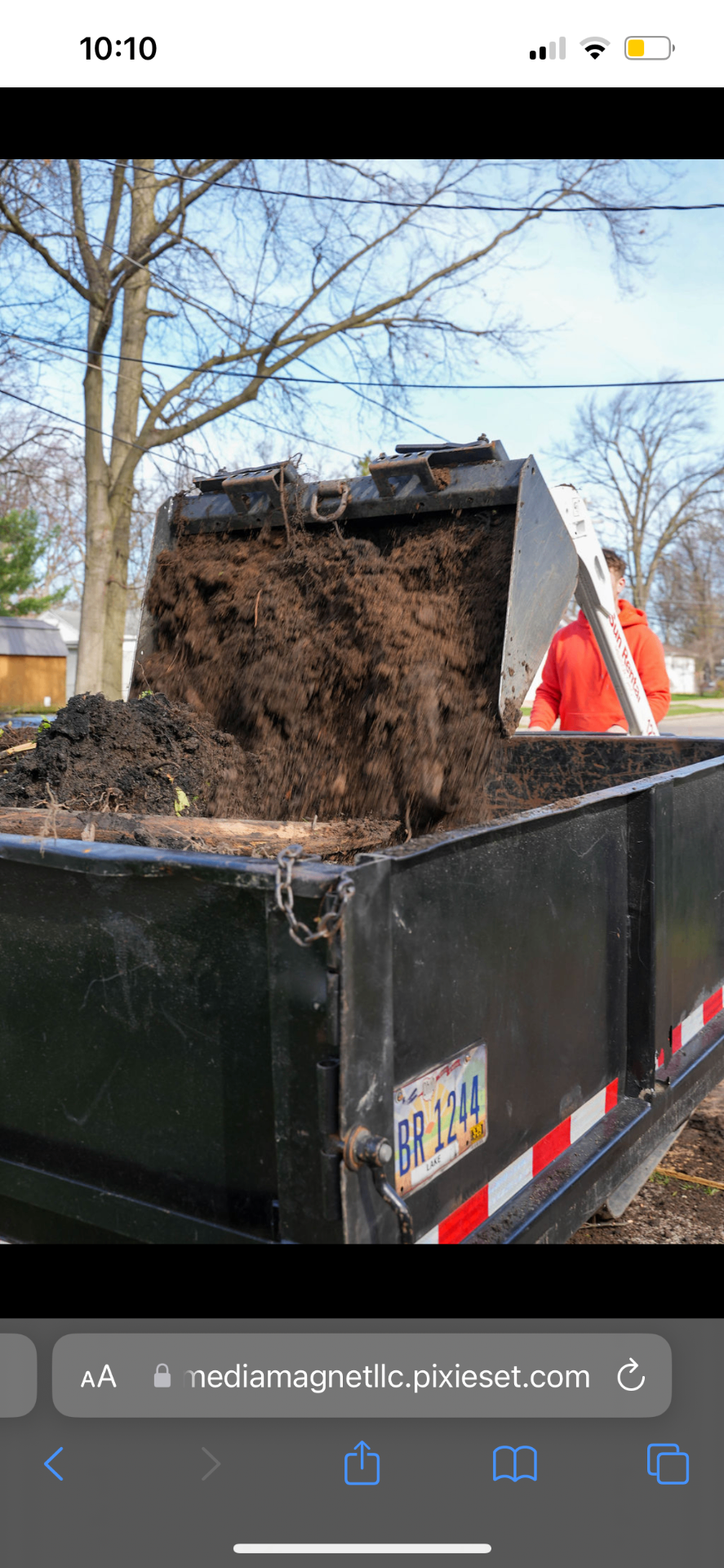 Skid steer loading fresh mulch into a dump trailer